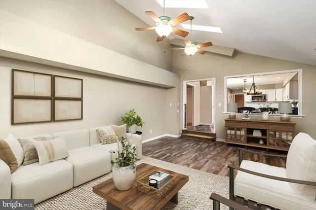 a view of a dining room and livingroom with furniture wooden floor a chandelier