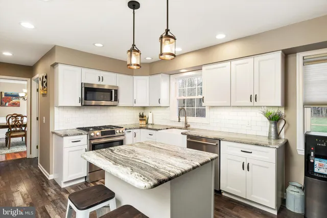 a kitchen with granite countertop a sink a stove and refrigerator