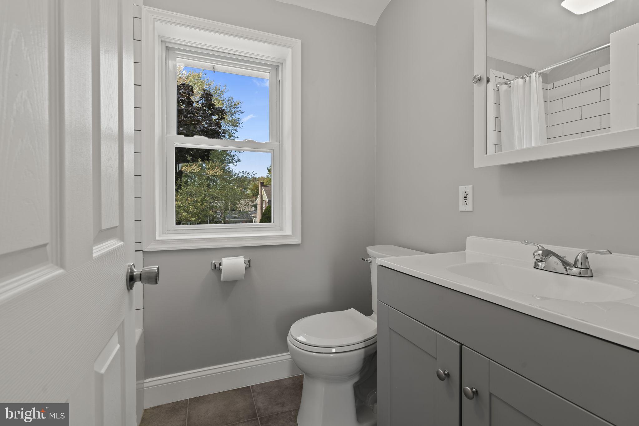 416 Adair Road Holmes, PA 19043 - Photo 14 of 32 a bathroom with a toilet sink vanity and mirror