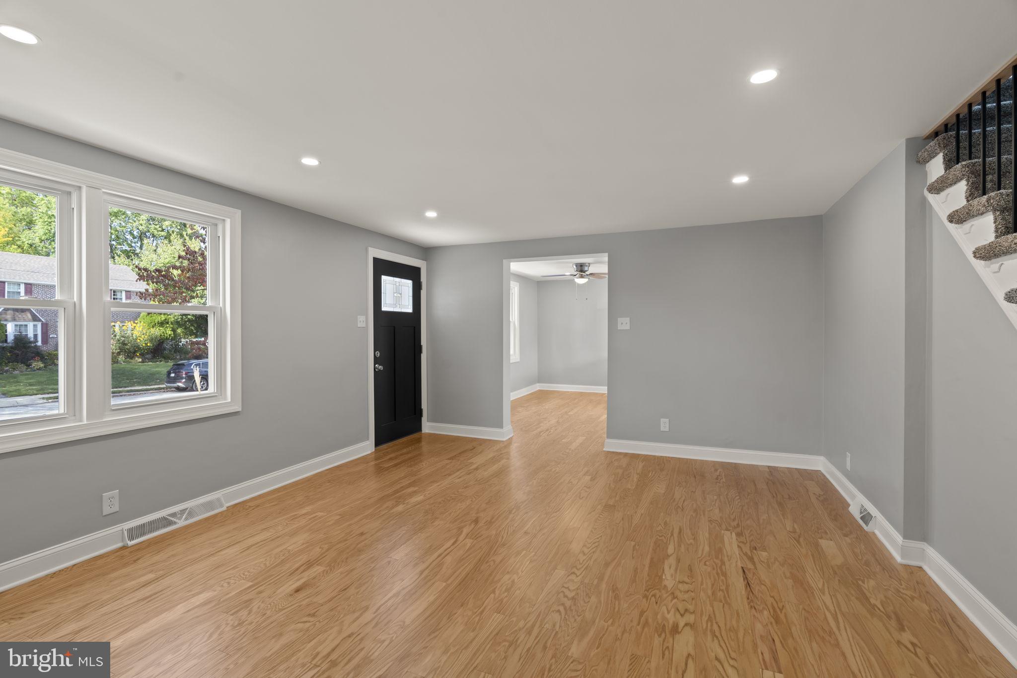 416 Adair Road Holmes, PA 19043 - Photo 3 of 32 a view of an empty room with wooden floor and a window