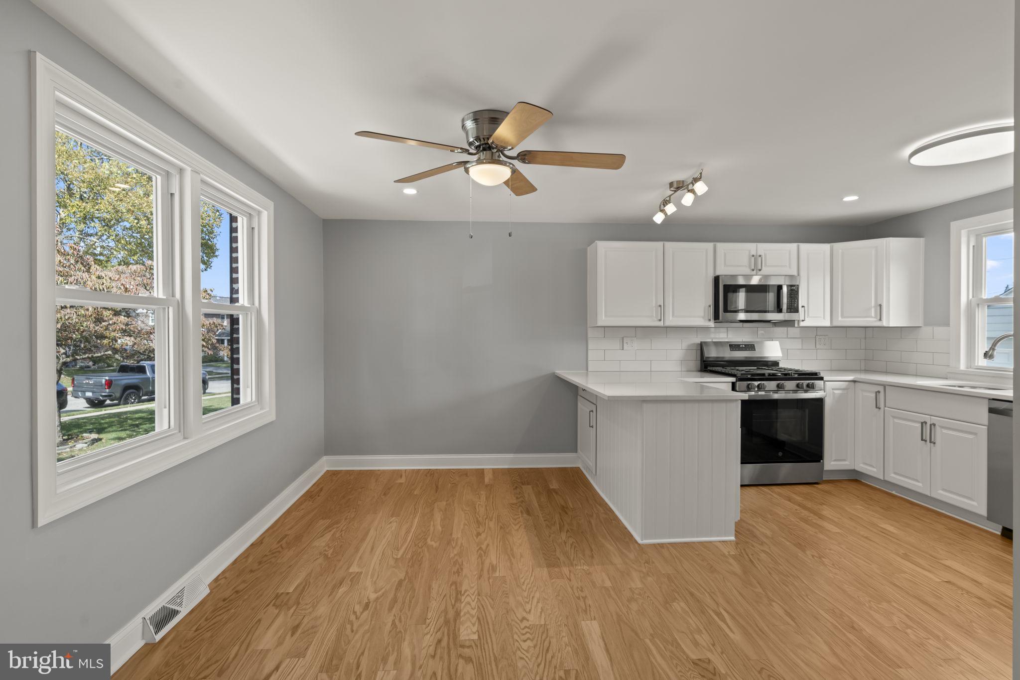 416 Adair Road Holmes, PA 19043 - Photo 6 of 32 a kitchen with wooden floors and white appliances