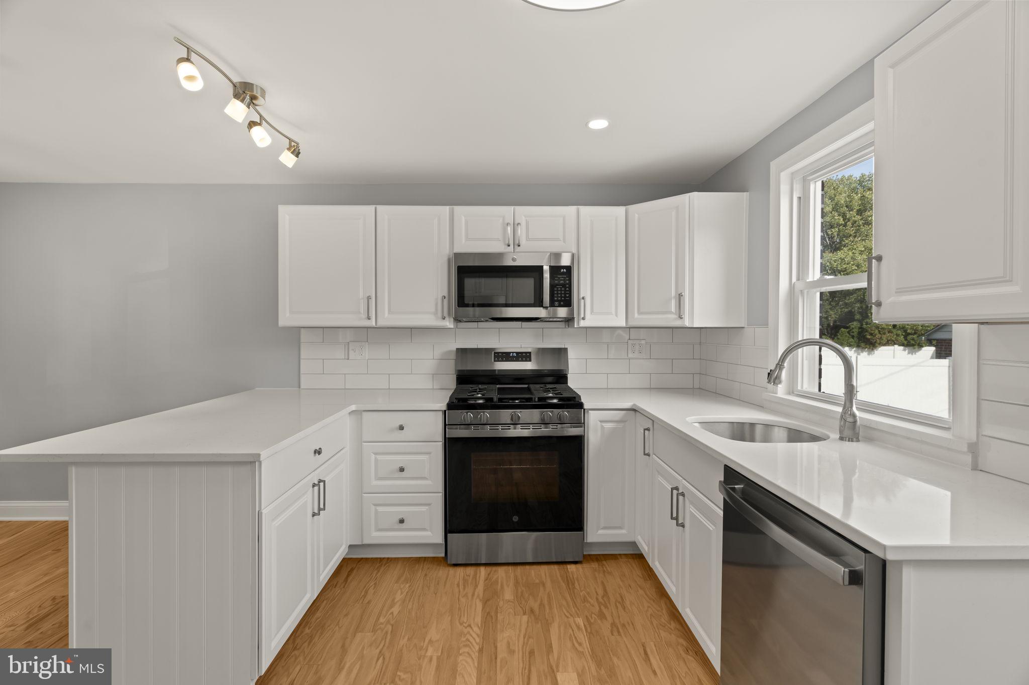 416 Adair Road Holmes, PA 19043 - Photo 8 of 32 a kitchen with a sink stove and microwave