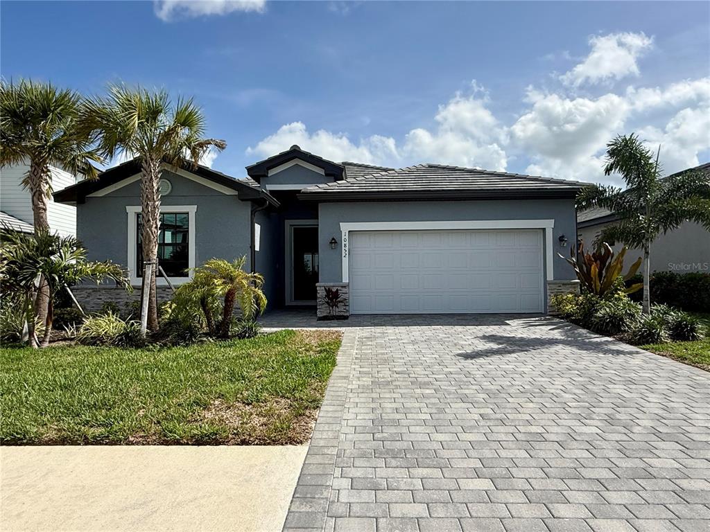10852 Sun Drop Street Venice, FL 34293 - Photo 1 of 15 a front view of a house with a yard and garage