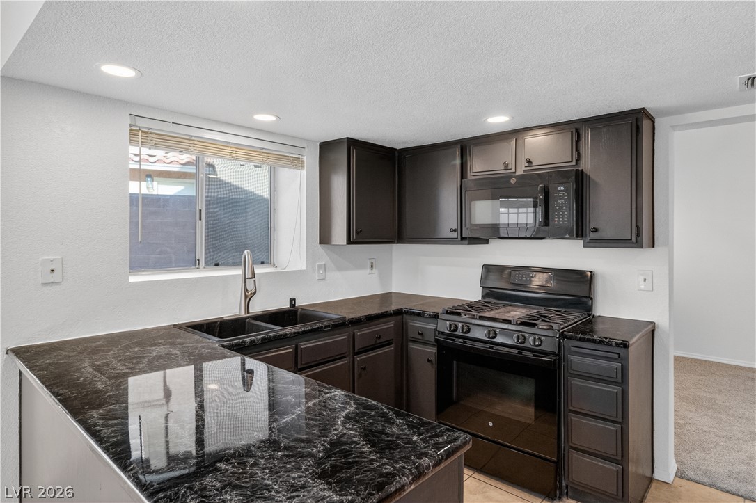 3156 Terrace View Drive Laughlin, NV 89029 - Photo 14 of 94 Efficiently designed kitchen offers dark cabinetry, modern appliances, and ample counter space for culinary endeavors.