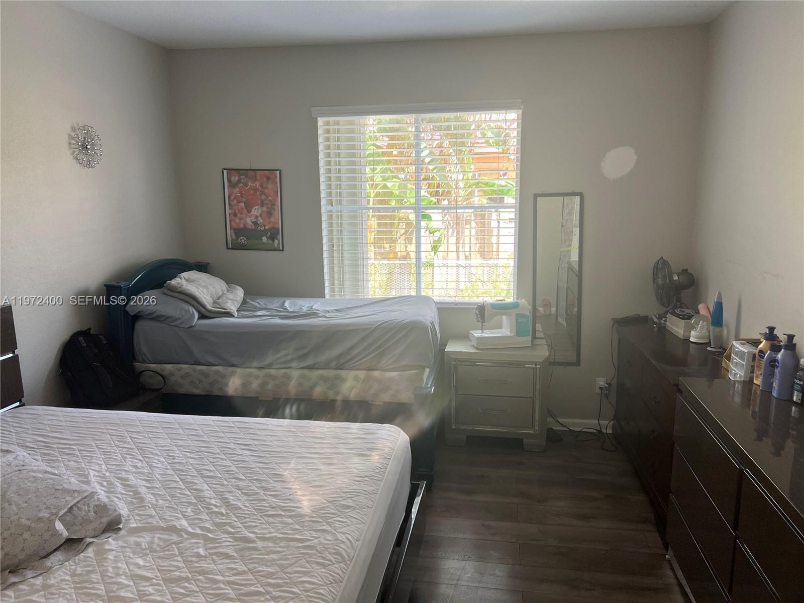 95 Southwest 15th Road Homestead, FL 33030 - Photo 13 of 42 a bedroom with a bed and wooden floor