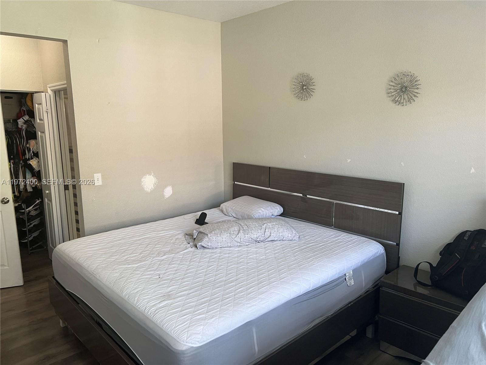 95 Southwest 15th Road Homestead, FL 33030 - Photo 16 of 42 a bedroom with a bed and a lamp on table