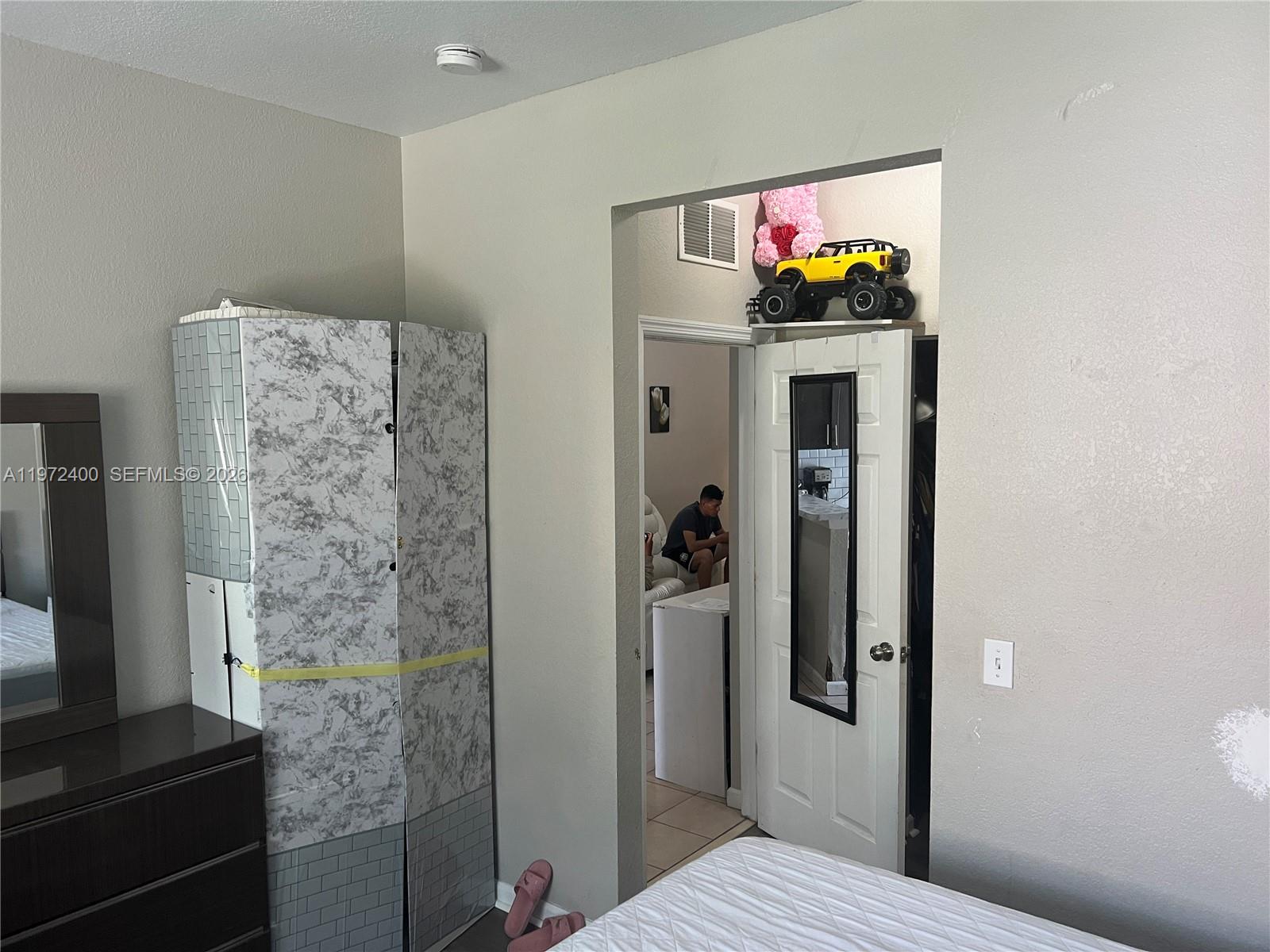 95 Southwest 15th Road Homestead, FL 33030 - Photo 17 of 42 a bedroom with a bed and a flat screen tv