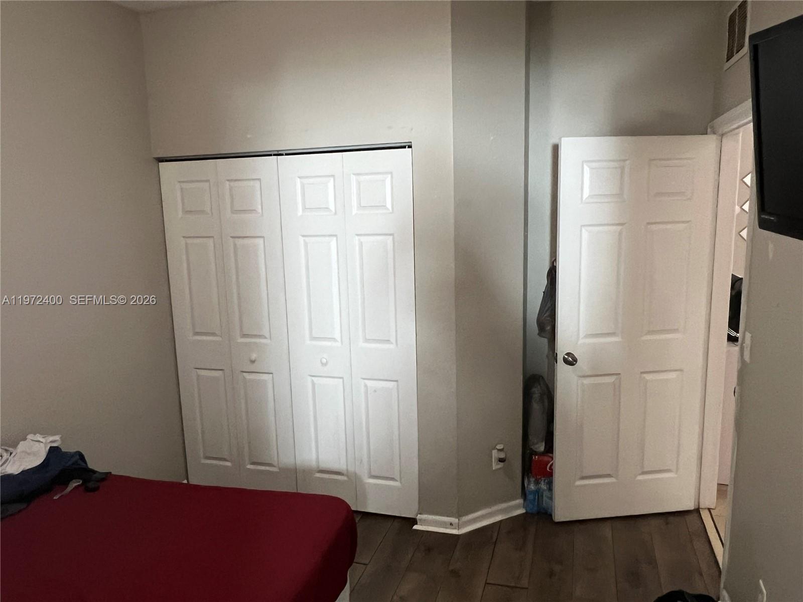 95 Southwest 15th Road Homestead, FL 33030 - Photo 26 of 42 a bedroom with a bed and wooden floor