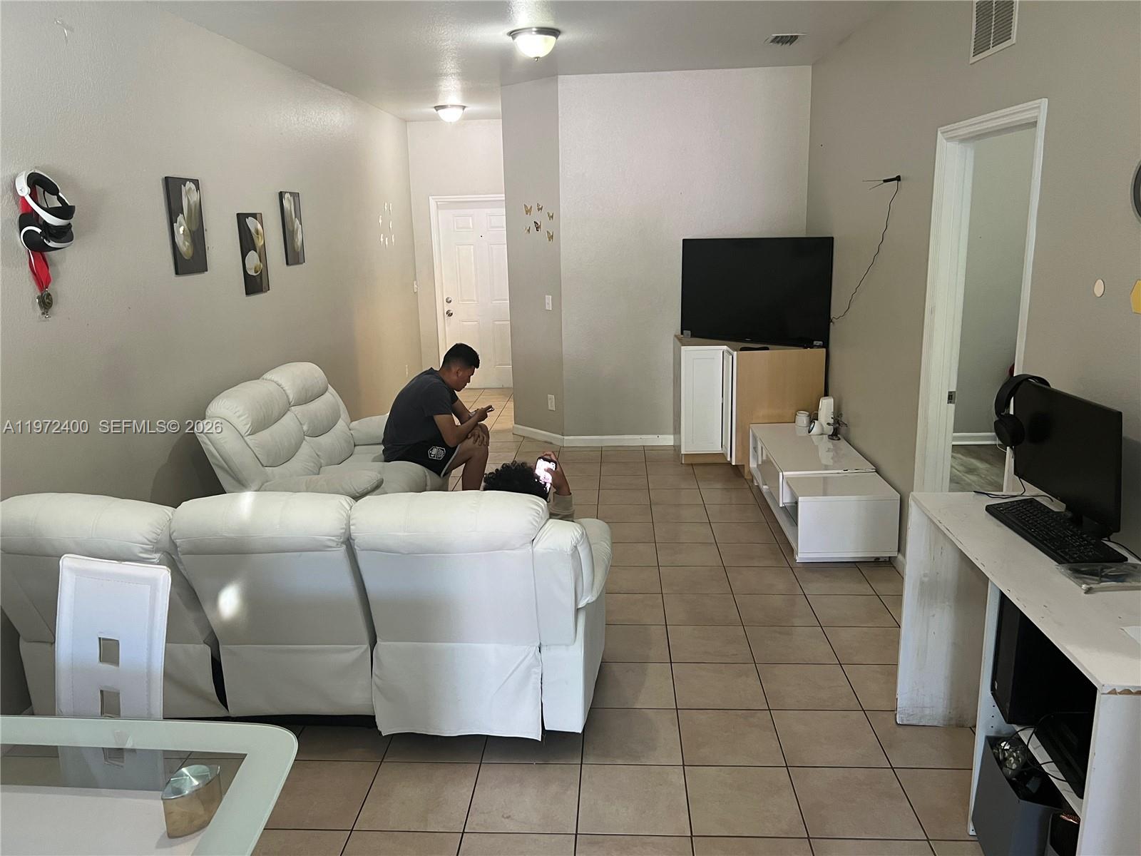 95 Southwest 15th Road Homestead, FL 33030 - Photo 3 of 42 a living room with furniture and a flat screen tv