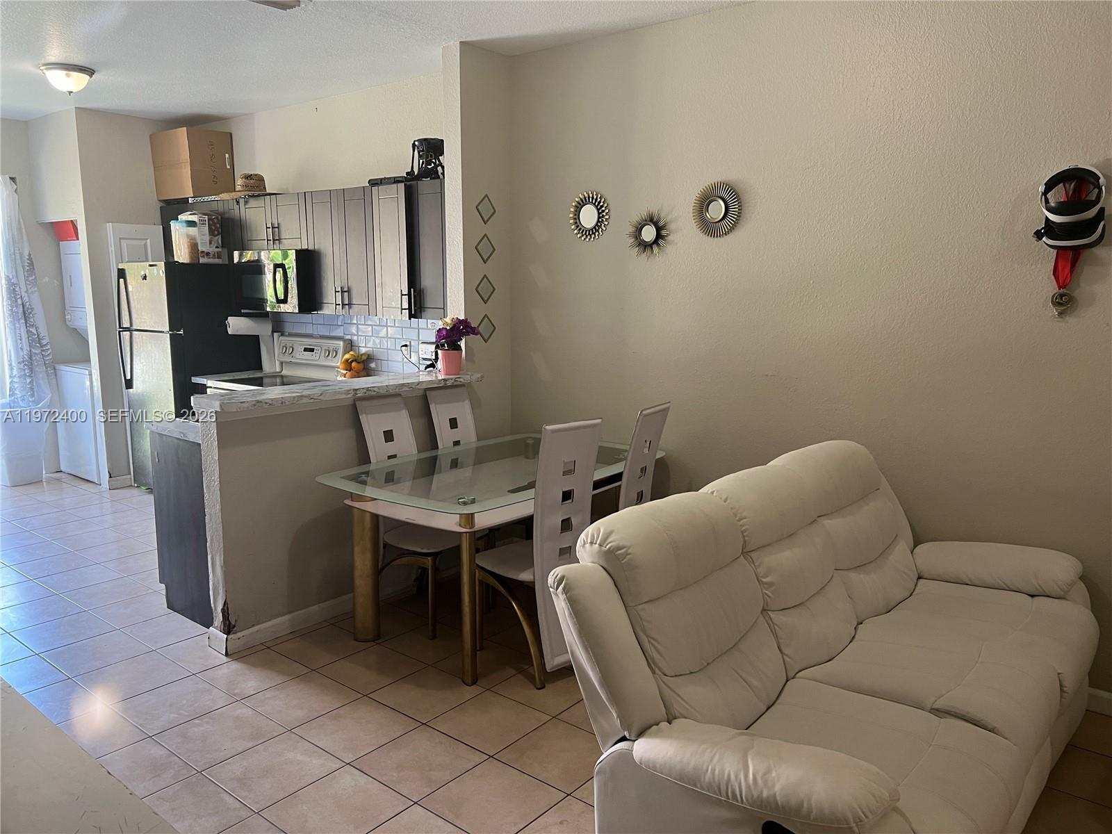 95 Southwest 15th Road Homestead, FL 33030 - Photo 4 of 42 a living room with furniture a flat screen tv and a table