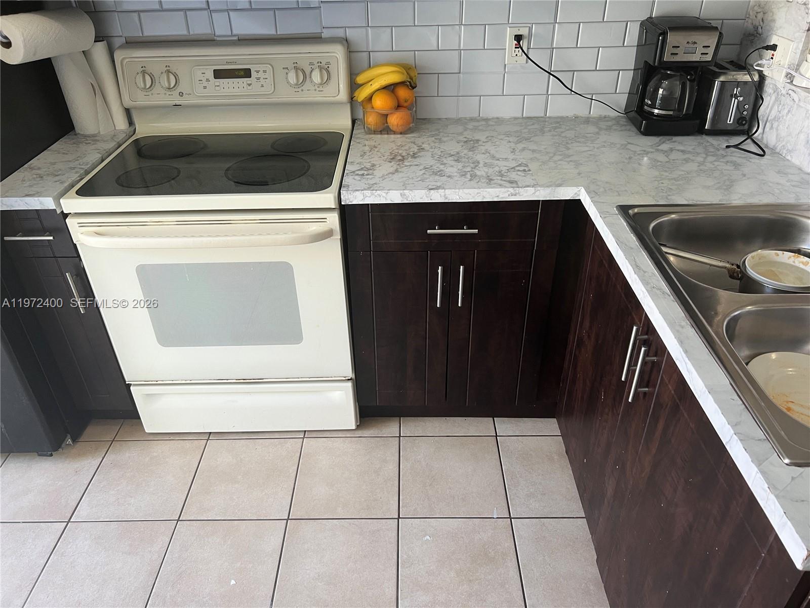 95 Southwest 15th Road Homestead, FL 33030 - Photo 10 of 42 a kitchen with a stove top oven and cabinets