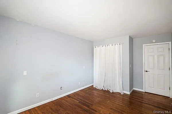 a view of room with window and hardwood floor