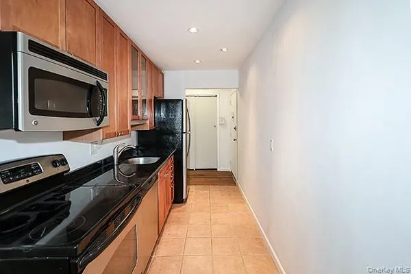 a view of an empty room with wooden floor closet and windows