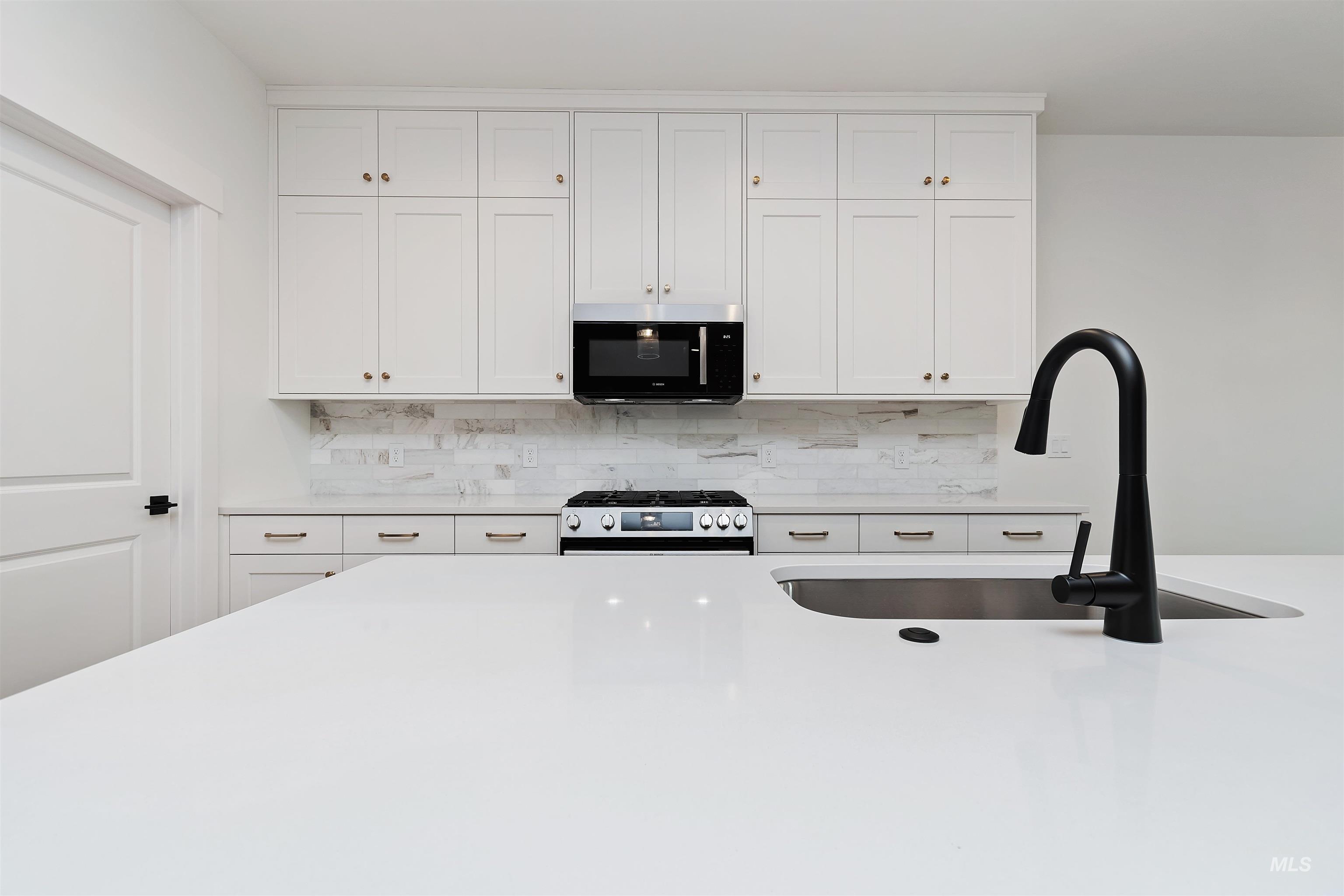 4302 Tropic Way Caldwell, ID 83607 - Photo 10 of 32 Kitchen featuring white cabinetry, stainless steel gas stove, light stone countertops, and tasteful backsplash