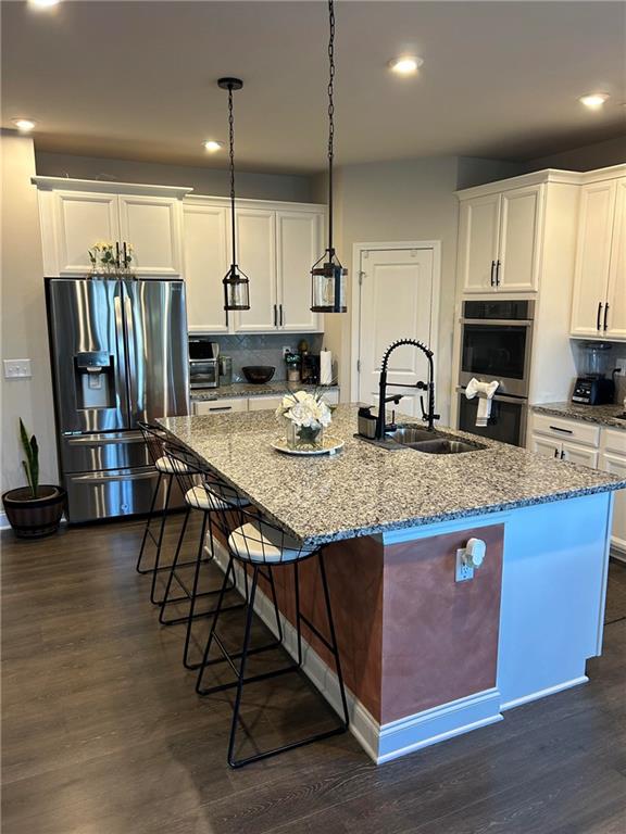 5860 Stargazer Way Cumming, GA 30028 - Photo 11 of 36 a kitchen with granite countertop a table chairs microwave and sink