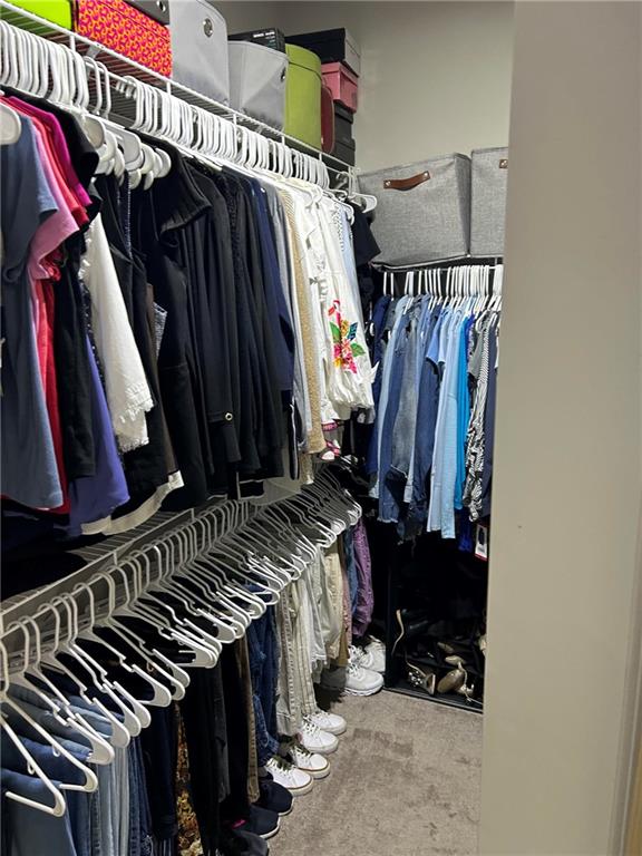 5860 Stargazer Way Cumming, GA 30028 - Photo 20 of 36 a view of walk in closet with clothes and shoes