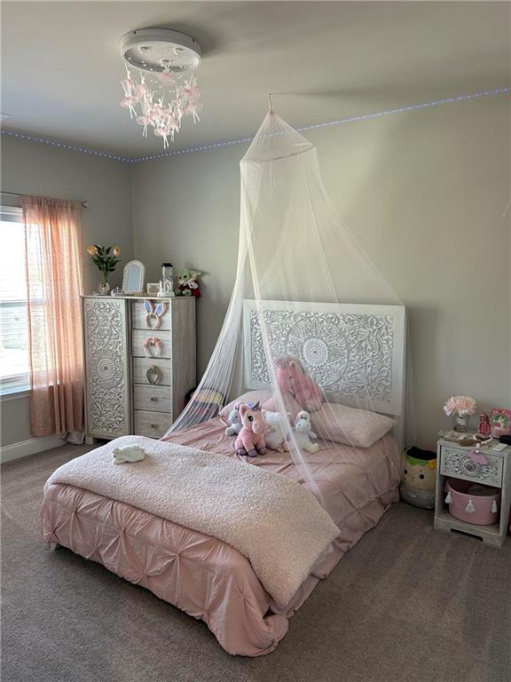 5860 Stargazer Way Cumming, GA 30028 - Photo 28 of 36 a bedroom with a bed and a chandelier