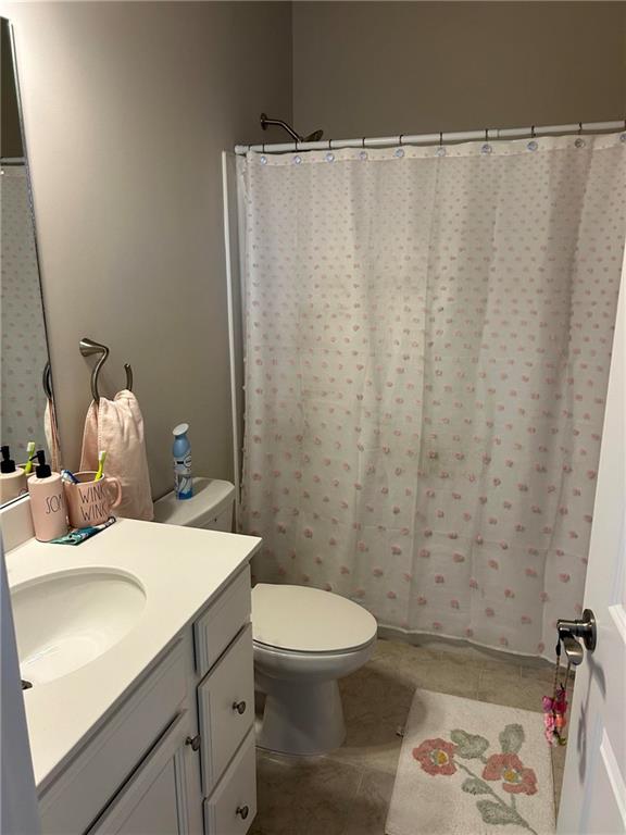 5860 Stargazer Way Cumming, GA 30028 - Photo 29 of 36 a bathroom with a sink a toilet and shower curtain