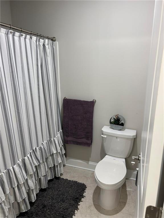 5860 Stargazer Way Cumming, GA 30028 - Photo 31 of 36 a bathroom with a toilet and a shower curtain