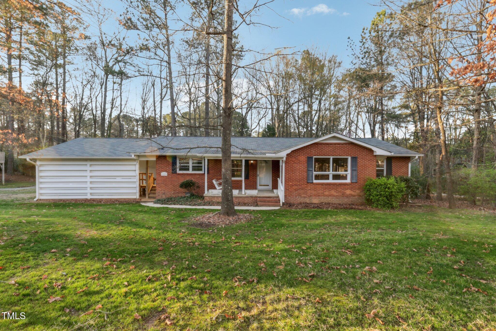 209 High House Road Cary, NC 27513 - Photo 1 of 40 a front view of a house with a garden