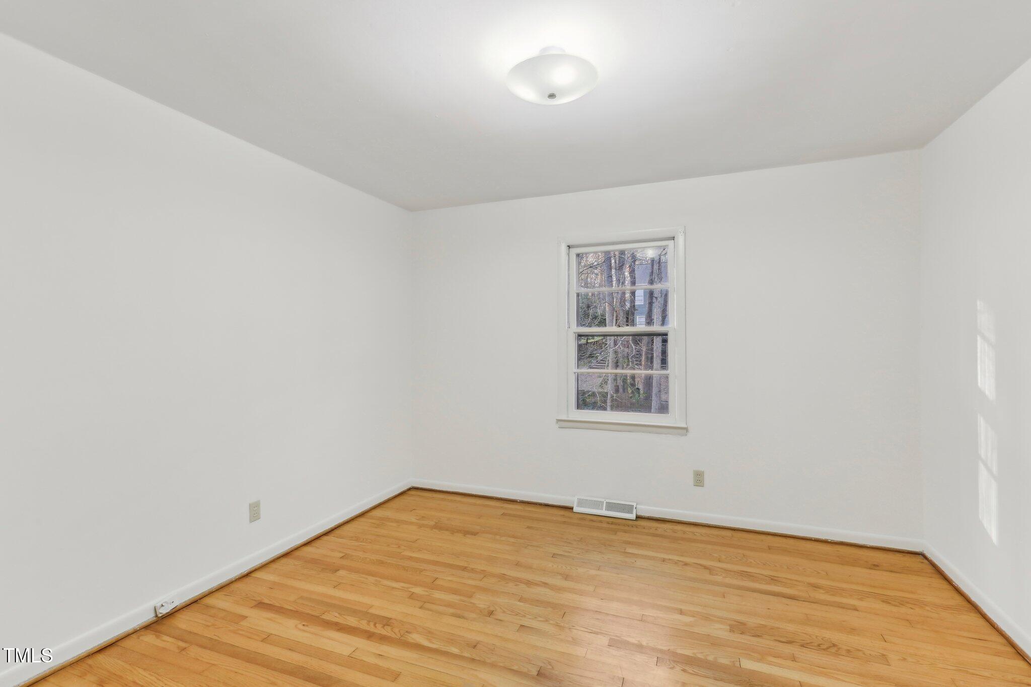 209 High House Road Cary, NC 27513 - Photo 16 of 40 an empty room with wooden floor and windows