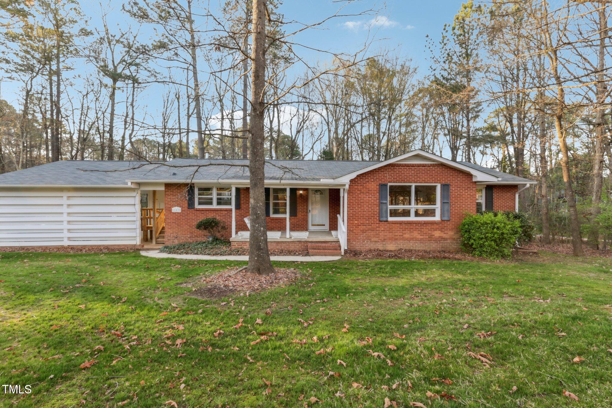 209 High House Road Cary, NC 27513 - Photo 38 of 40 a front view of a house with a garden