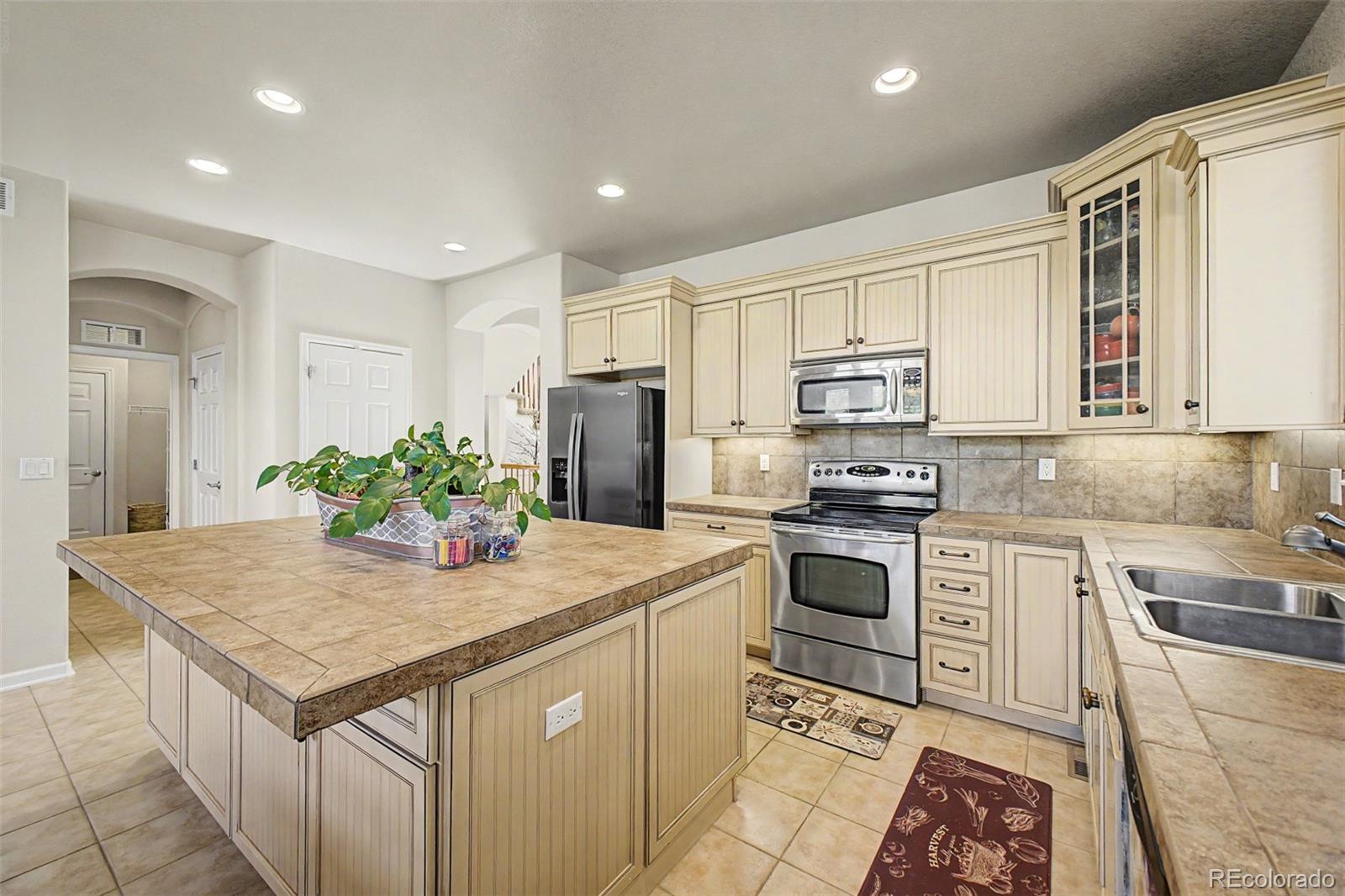 3343 Fantasy Place Castle Rock, CO 80109 - Photo 10 of 50 a kitchen with stainless steel appliances granite countertop a kitchen island hardwood floor sink and stove