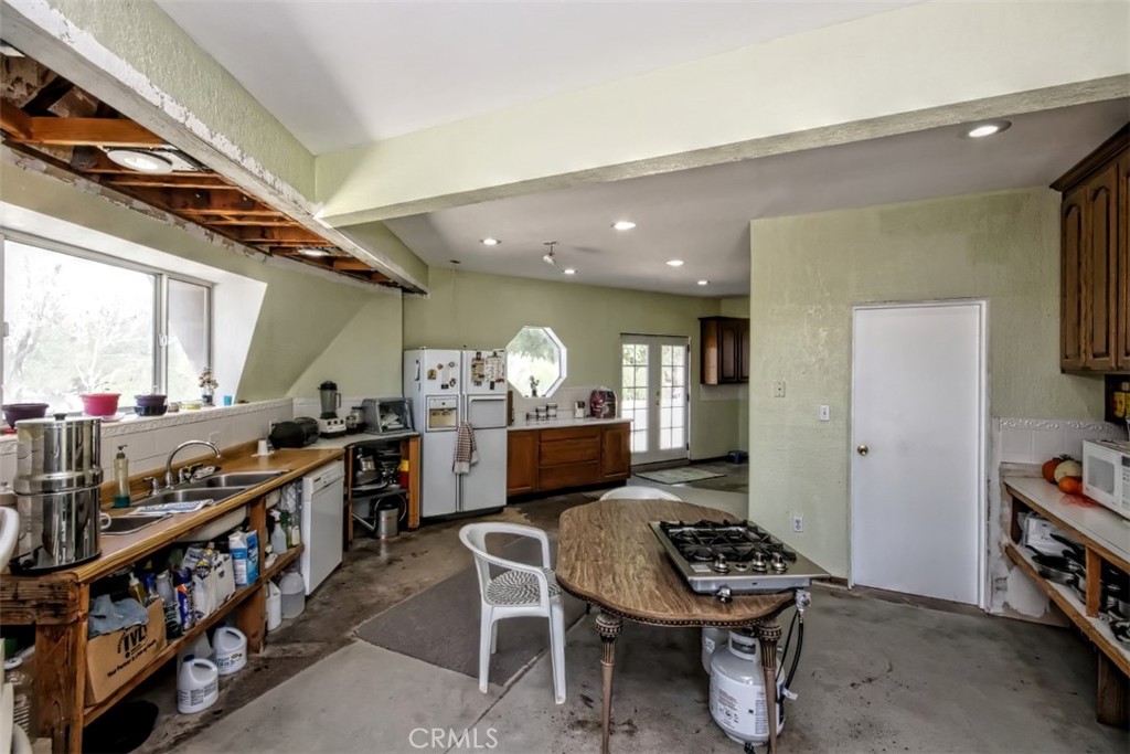 45985 Cottonwood Road Newberry Springs, CA 92365 - Photo 15 of 67 a kitchen with stainless steel appliances kitchen island a table and chairs in it