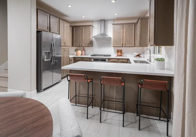 a kitchen with kitchen island granite countertop wooden cabinets and refrigerator