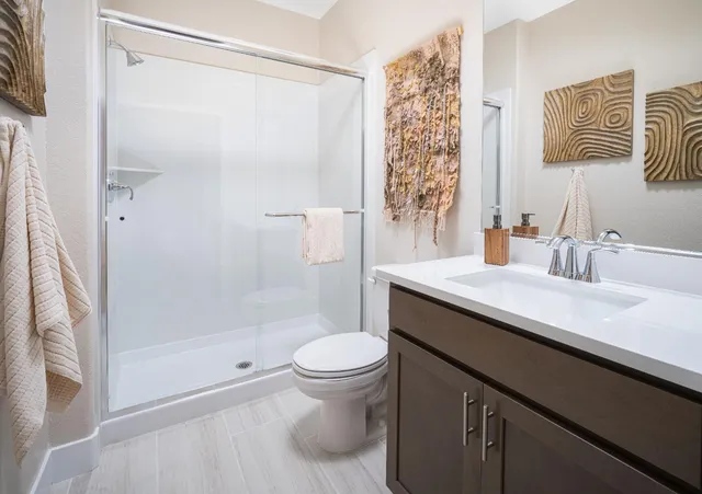 a bathroom with a sink a toilet and shower