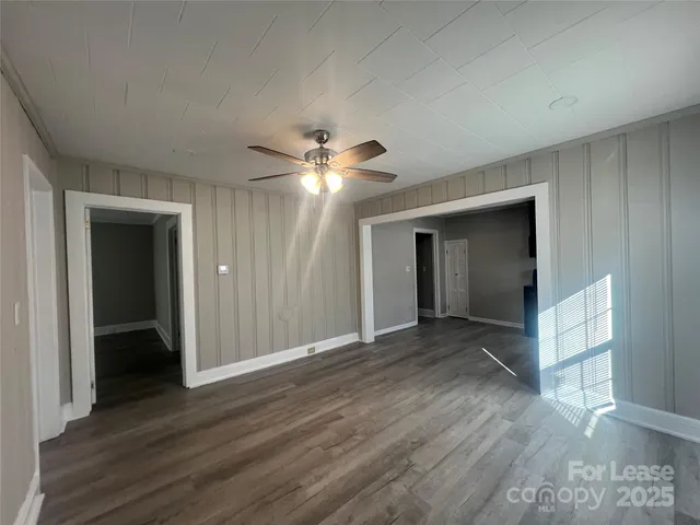 a view of an empty room with wooden floor and closet