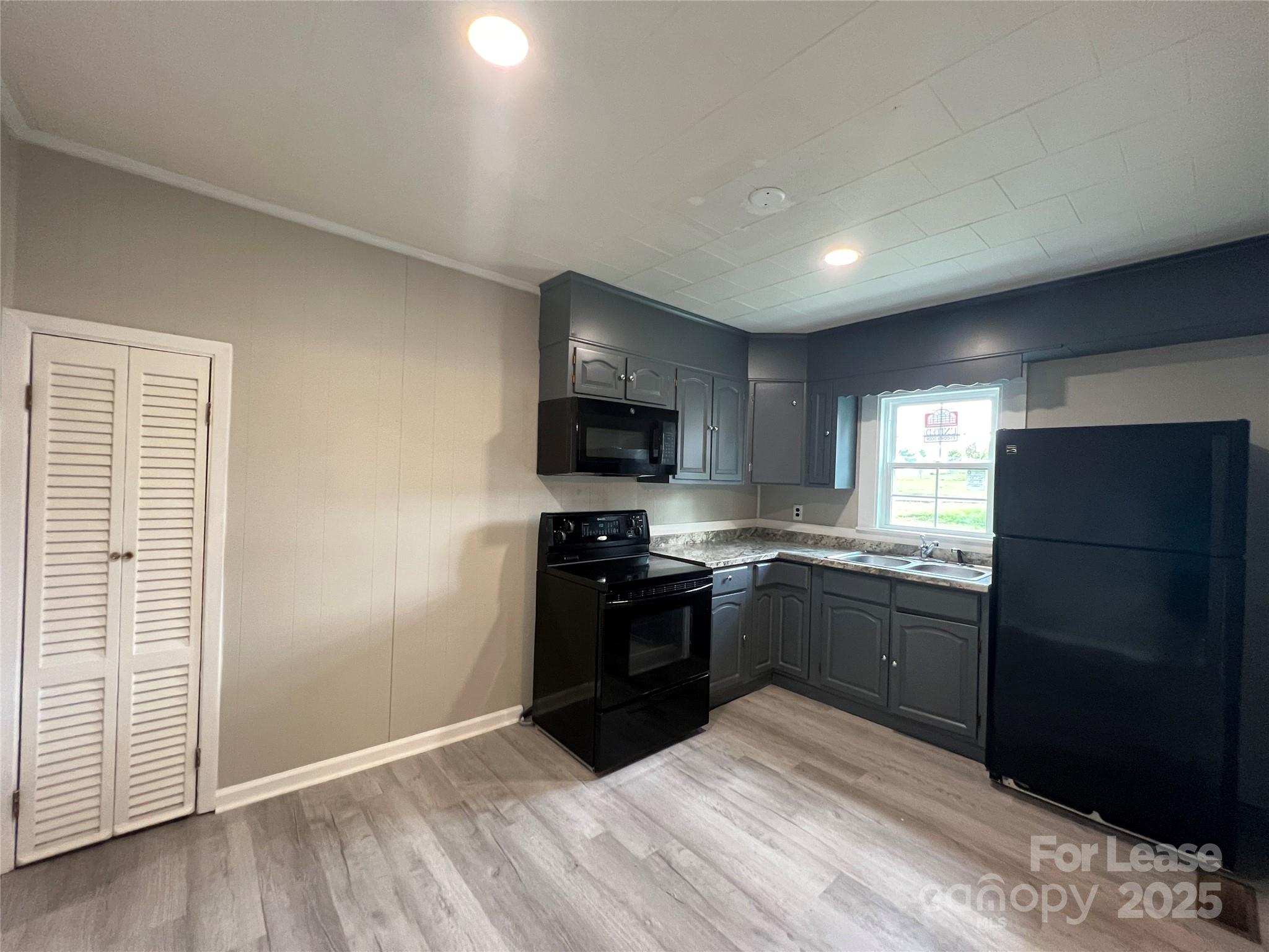 111 East Maryland Avenue Bessemer City, NC 28016 - Photo 4 of 11 a kitchen with granite countertop stainless steel appliances and wooden cabinets