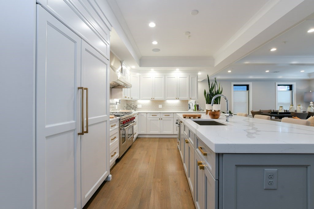 377 West First Street, Unit 2 Boston, MA 02127 - Photo 13 of 39 a large white kitchen with a large window a sink and stainless steel appliances