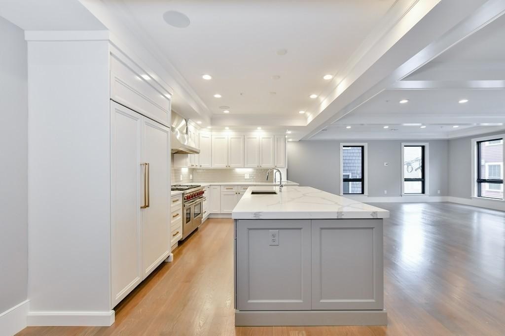 377 West First Street, Unit 2 Boston, MA 02127 - Photo 24 of 39 a kitchen with a sink stainless steel appliances and white cabinets
