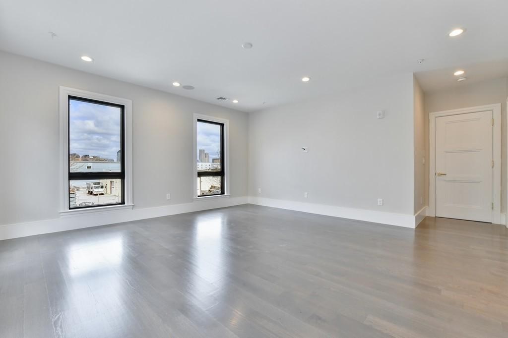 377 West First Street, Unit 2 Boston, MA 02127 - Photo 25 of 39 a view of an empty room with wooden floor and windows