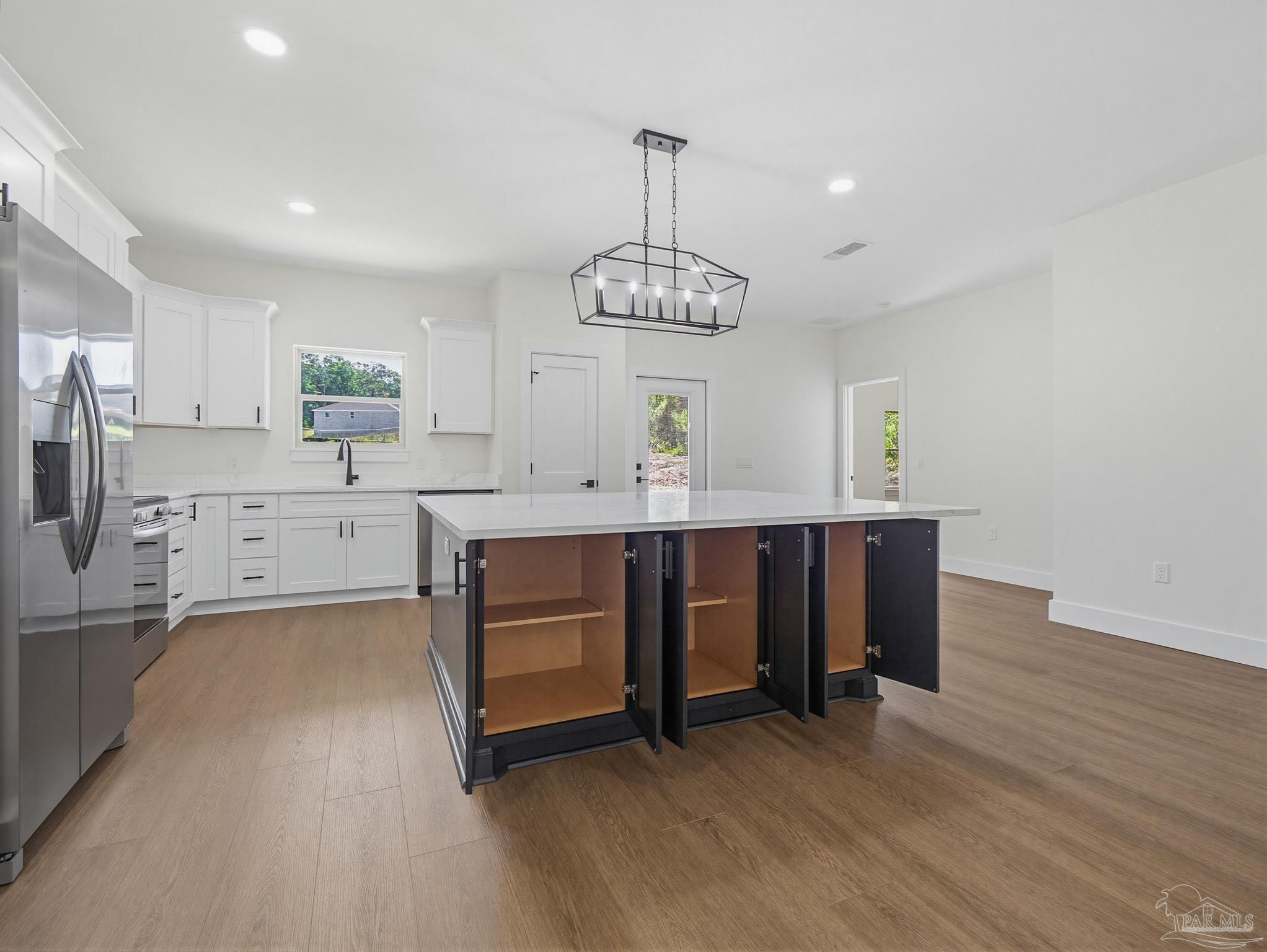5724 Riviera Drive Milton, FL 32583 - Photo 16 of 52 a kitchen with stainless steel appliances a dining table chairs sink and cabinets
