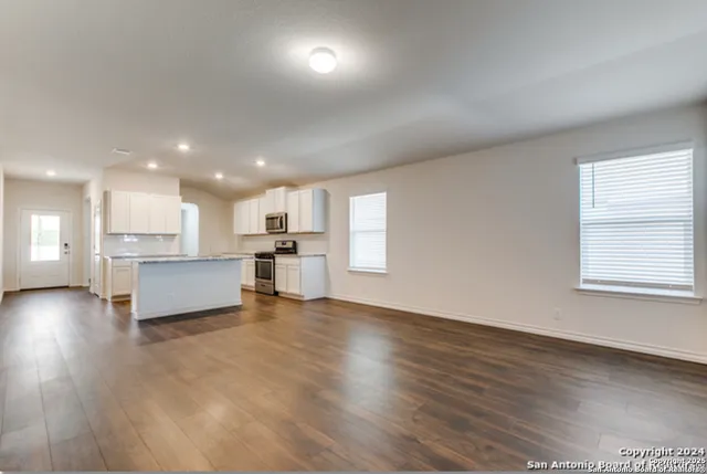a view of kitchen with kitchen island wooden floor and center island