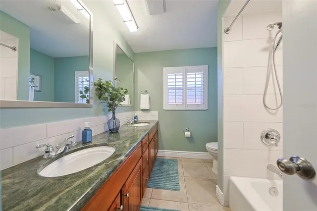 a bathroom with a granite countertop sink mirror bathtub and shower