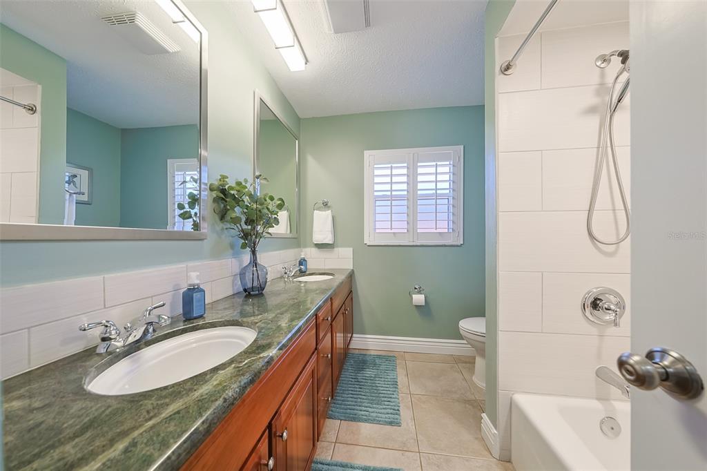 914 Chipaway Drive Apollo Beach, FL 33572 - Photo 25 of 49 a bath room with a granite countertop sink and a mirror