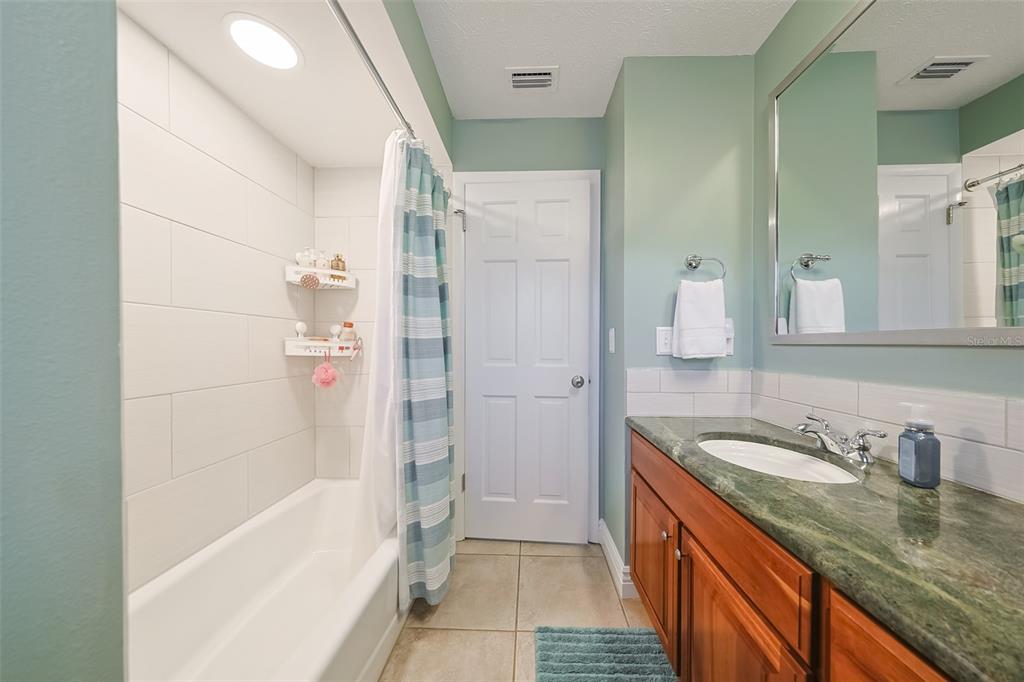 914 Chipaway Drive Apollo Beach, FL 33572 - Photo 26 of 49 a bathroom with a granite countertop sink mirror bathtub and shower