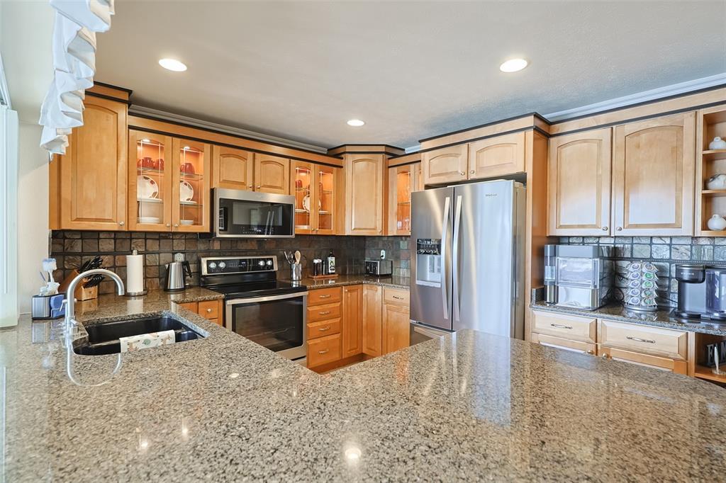 914 Chipaway Drive Apollo Beach, FL 33572 - Photo 41 of 49 a kitchen with stainless steel appliances granite countertop a refrigerator stove top oven and sink