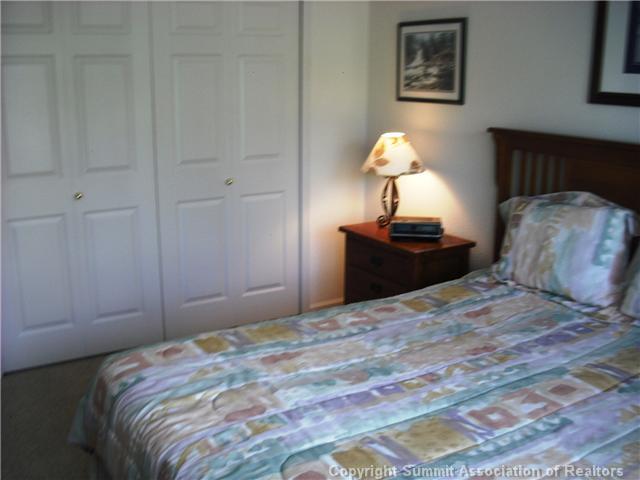 110 Beaver Lodge Road, Unit 103 Frisco, CO 80443 - Photo 20 of 25 a bedroom with a bed and a chandelier