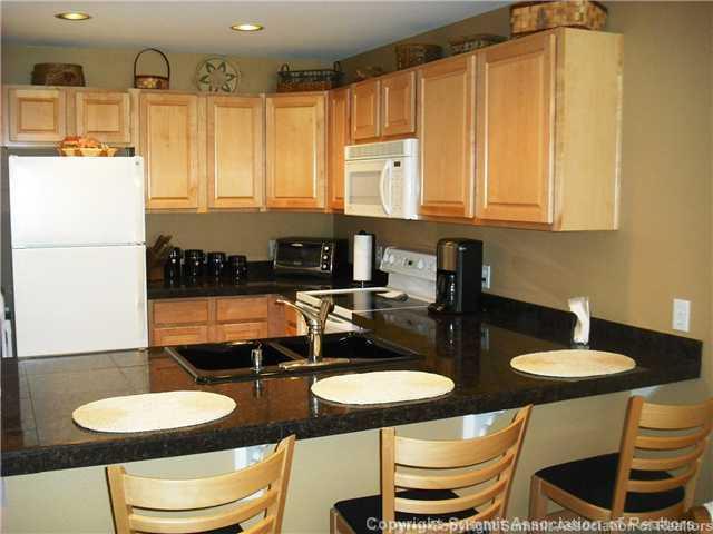 110 Beaver Lodge Road, Unit 103 Frisco, CO 80443 - Photo 8 of 25 a kitchen with stainless steel appliances granite countertop a table chairs and a refrigerator