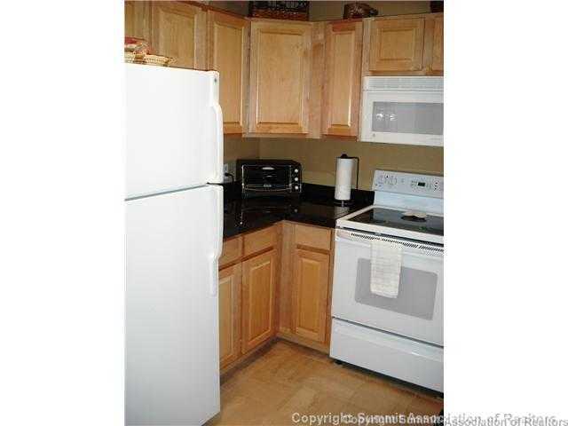 110 Beaver Lodge Road, Unit 103 Frisco, CO 80443 - Photo 10 of 25 a kitchen with a white cabinets and white appliances