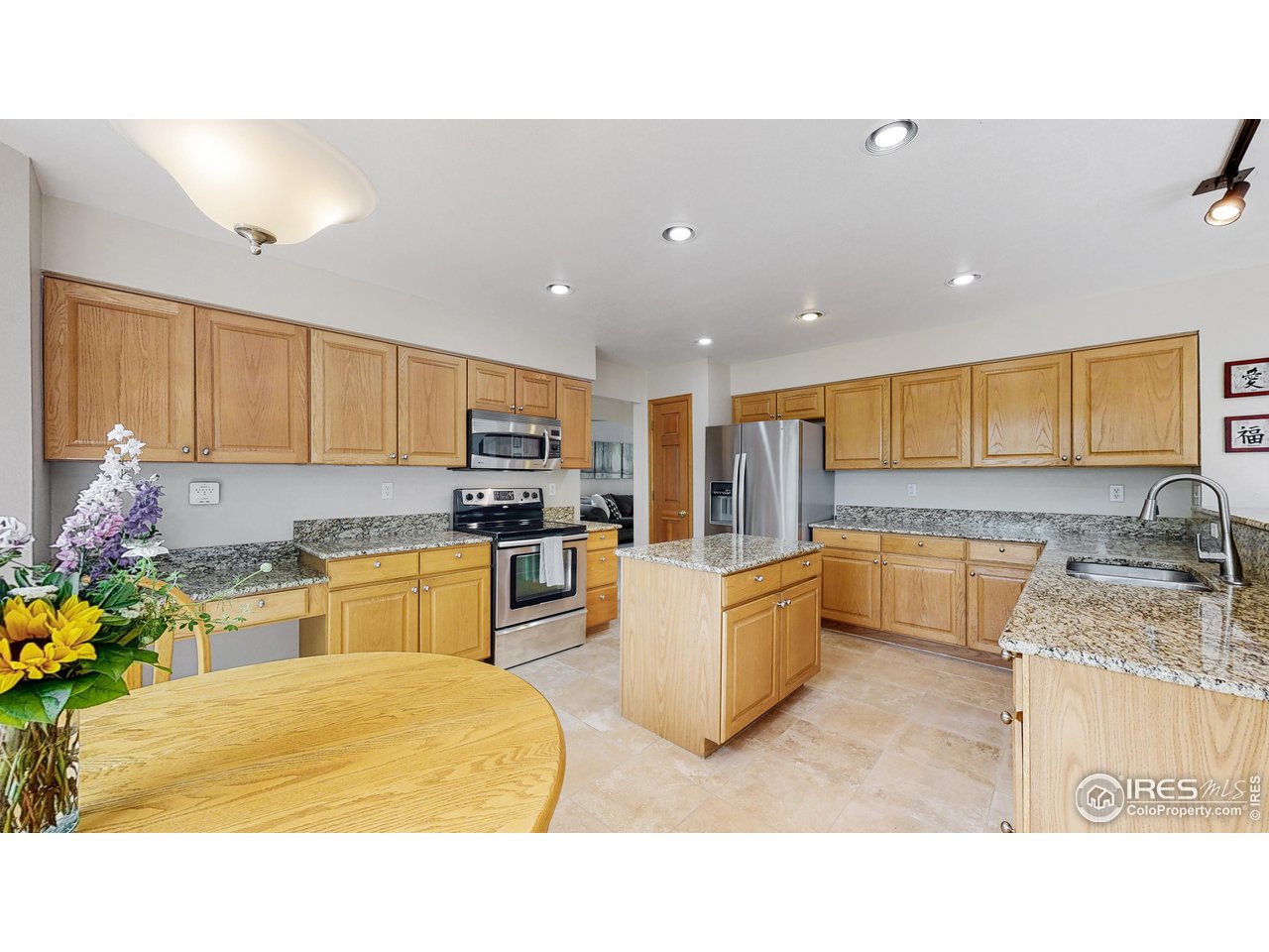 9951 South Spring Hill Place Highlands Ranch, CO 80129 - Photo 5 of 40 a kitchen with kitchen island granite countertop a sink counter top space appliances and cabinets