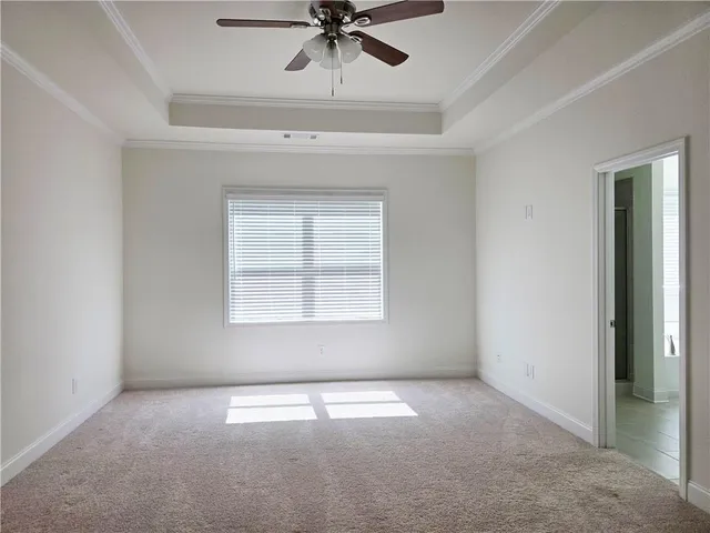an empty room with a window and a ceiling fan
