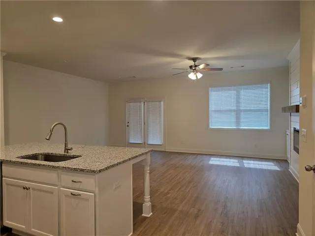 a kitchen with a sink cabinets a wooden floor and a window