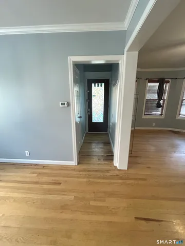 a view of a hallway with wooden floor and closet
