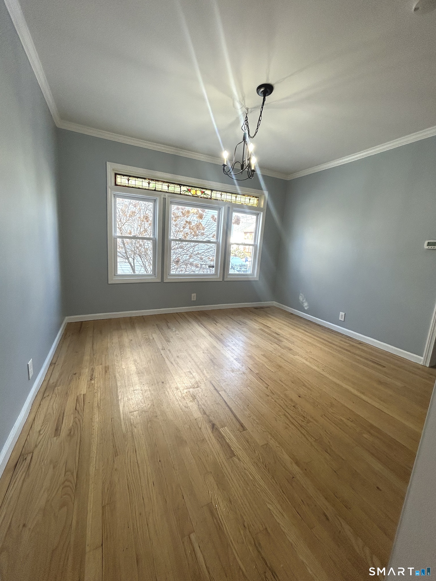 143 Wilson Street Bridgeport, CT 06605 - Photo 9 of 12 an empty room with wooden floor and windows