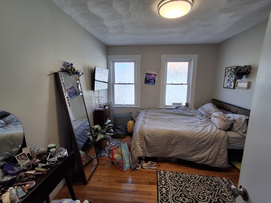 24 French Street, Unit 24 Watertown, MA 02472 - Photo 6 of 9 a bedroom with a bed and wooden floor